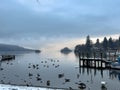 Lake Windermere, Lake District in England. Winter with snow. Calm still water with birds boats and swans