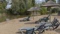 Lakeside beach with grass umbrellas Royalty Free Stock Photo