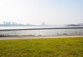 Lakeside fenced path and lawn in sunny winter afternoon