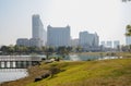 Lakeside grassy ramp in misty modern city at sunny winter noon