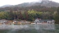 Lakeside houses on Lake Kinrin with forests and mountains behind on a rainy and moisty day