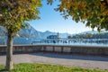 Lakeside promenade with view autumnal chestnut trees and water castle, called Schloss Orth, harbor at Traunsee lake, Salzkammergut