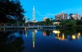 Lakeside scenery of Taipei 101 Tower among skyscrapers in Xinyi District Downtown at dusk with view of reflections on the pond