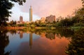 Lakeside scenery of Taipei 101 Tower among skyscrapers in Xinyi District Downtown at dusk with view of reflections on the pond