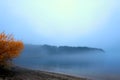 Lakeside shore and islands hidden behind thick fog Royalty Free Stock Photo