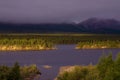 Lakeside in sunset light and low clouds in the mountains.