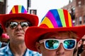 A woman and man are wearing sunglasses and matching rainbow hats to show LGBTQ support at Gay Pride Royalty Free Stock Photo