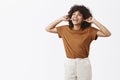 Lalala cannot hear you. Portrait of carefree indifferent and happy young african american girl in brown t-shirt covering Royalty Free Stock Photo