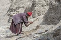 Old tibetan woman working in yard near Lamayuru monastery in Ladakh, India