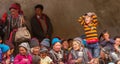 Curious funny boy and older ladakhi women with hand prayer wheels in traditional clothes and jewelry on buddhist festival