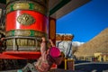 A LITTLE BOY PLAYS WITH PRAYER WHEEL IN LAMAYURU MONASTERY