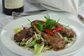 Lamb chop with salad and pepper on a plate.