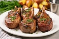 lamb chops with grill marks plated with potatoes