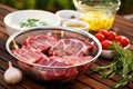 lamb chops marinating in a bowl next to a grill Royalty Free Stock Photo