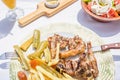 Lamb chops with vegetables and roast potatoes on a plate in a Greek restaurant or tavern. Royalty Free Stock Photo