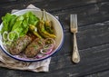 Lamb kebab, spicy roasted peppers and fresh green salad on the plate on a dark wooden surface