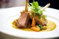 lamb korma plated elegantly with a sprig of coriander, close-up