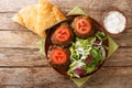 Lamb Patties Chapli Kebab with fresh vegetables close up in the plate. Horizontal top view