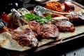 Lamb rack cooked on the grill with pita bread, bulgur and grilled vegetables on a wooden board. Turkish shashlik. Close up,