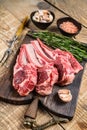 Lamb raw cutlets chops with salt, pepper and garlic. wooden background. Top view