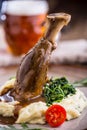 Lamb shank.Confit lamb shank with mashed potatoes spinach and draft beer in pub or restaurant Royalty Free Stock Photo