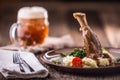 Lamb shank.Confit lamb shank with mashed potatoes spinach and draft beer in pub or restaurant Royalty Free Stock Photo