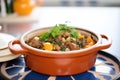 lamb tagine in pot with lid off, on tiled countertop
