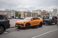 Lamborghini Urus parked on the street in Moscow. Orange supercar of old residential buildings Royalty Free Stock Photo