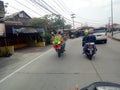 Lamongan, East Java, Indonesia. a motorcyclist carrying a kite in the shape of a green dragon's head