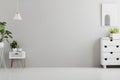 Lamp above white cabinet with plant in grey living room interior with poster and copy space. Real photo.Place for your sofa Royalty Free Stock Photo