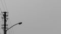 Lamp on a background of gray sky. Pillar with power cables. Pillar with power cables. Black and white photo. Royalty Free Stock Photo