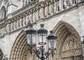 A lamp in the background of the main facade of Notre Dame de Paris