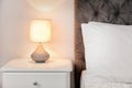 Lamp on bedside table in modern room Royalty Free Stock Photo
