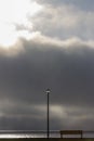 lamp and bench in front of the dramatic clouds sky background Royalty Free Stock Photo