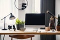 Lamp and desktop computer on wooden desk in modern freelancer`s Royalty Free Stock Photo