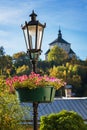Lamp with flowers and new castle in background in Banska Stiavni