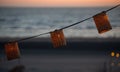 A lamp hangs on a wire against the background of a beach sunset