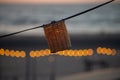 A lamp hangs on a wire against the background of a beach sunset