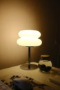 A lamp illuminates a desk with a jar of Marimo moss balls Royalty Free Stock Photo