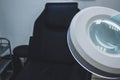 Lamp magnifier for beautician , workplace beautician, black chair Royalty Free Stock Photo