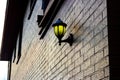 Lamp mounted on a brick wall illuminating golden light