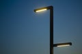 Lamp post against the background of the night sky. Modern lamppost with evening electric lighting. Minimal art Royalty Free Stock Photo