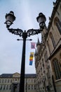 Lamp post at Burg Square during cloudy day, ancient building with flags and ornaments on the roof Royalty Free Stock Photo