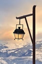 Lamp post in front of a beautiful sunset in snowy mountain Royalty Free Stock Photo