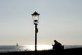 Lamp post and resting man Royalty Free Stock Photo