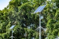 Lamp post with solar panel system on road with blue sky and trees. Autonomous street lighting using solar panels. Street lamp, on Royalty Free Stock Photo