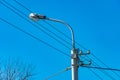 Lamp post with wires on blue sky background, city lighting Royalty Free Stock Photo