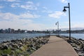 Lamp posts along a cement walkway with a view of Halifax Harbor on a sunny summer day