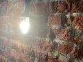 A lamp shines inside a brick building