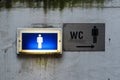 Lamp and signage with the sign of the men's room toilet on a old